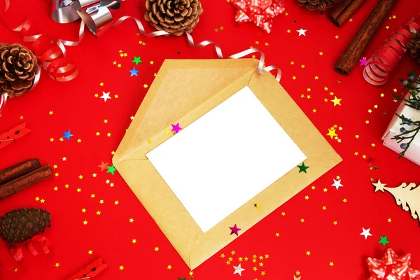 İçinde bir zarf ve çam kozalakları, tarçın çubukları, kurdeleler, konfeti ve fiyonklarla çevrili bir davetiye var. Yukarıdan bak. Model.