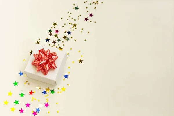 Şimdiki kutu yıldızların yolunda duruyor pastel arka planda konfeti. Noel havası için düz yatış tarzı. Tatil konsepti. Kopyalama alanı.