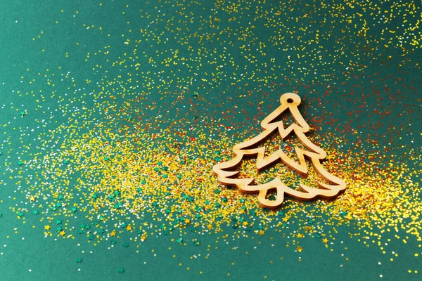 Yeşil arka planda parlak dekoratif Noel ağacı. Üst Manzara. Parlak festival konfetisi.