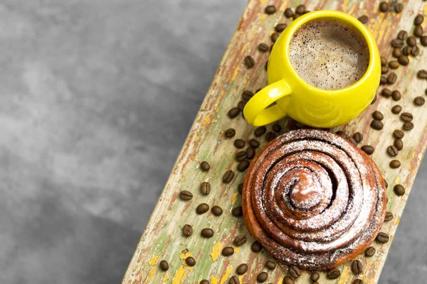 Bir fincan hoş kokulu kahve ve 2021 yılının en güzel sarı ve nihai gri renklerini gösteren modaya uygun bir kanelbulle. Kopyalama alanı.