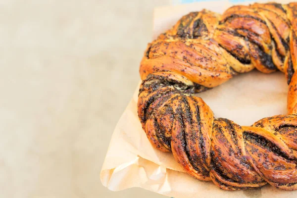 Hafif kâğıt fırında haşhaş tohumlu örülmüş çörek. Kopyalama uzayı. Üst görünüm.