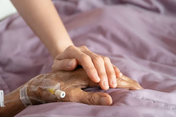 Asian people family, granddaughter visiting her grandfather at hospital. Very old Asian man got a sickness and health problem. Woman with face mask taking care her grandfather