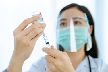 Coronavirus - 2019-nCoV veya COVID-19 aşı şişeleri sadece enjeksiyon için kullanılır. Doktor şişeden şırıngaya aşı çıkarıyor. COVID-19 aşısı kopyalama alanı ile yakın çekim.