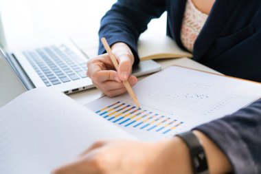 Şirketin yıllık raporunu inceleyen tanınmamış Asyalı iş kadını, mali grafik üzerinde çalışan üst düzey yönetici. İş kadını yıllık özet satış raporuna bakıyor..