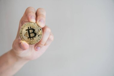 Altın bir Bitcoin ya da BTC 'yi fotokopi makinesiyle kameraya gösteren tanınmayan bir kadın. Bitcoin, engelleme zinciri teknolojisi tarafından desteklenen popüler dijital kripto para birimidir..