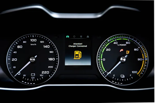 Digital modern dashboard in a electric vehicle - EV while charging at the charging station, battery electric vehicle or BEV. Dashboard in the vehicle showing charging status.