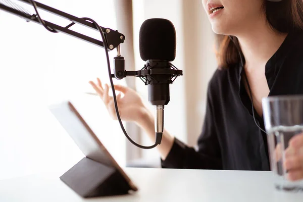 Güzel ve yakışıklı Asyalı kadın podcast kanalını düzenliyor. İş kadını internetteki yayını için bilgisayarından ve tabletinden canlı yayın yapıyor. Modern çalışma tarzı