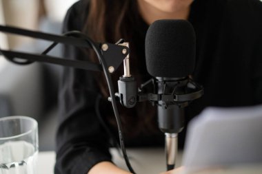 Güzel ve yakışıklı Asyalı kadın podcast kanalını düzenliyor. İş kadını internetteki yayını için bilgisayarından ve tabletinden canlı yayın yapıyor. Modern çalışma tarzı