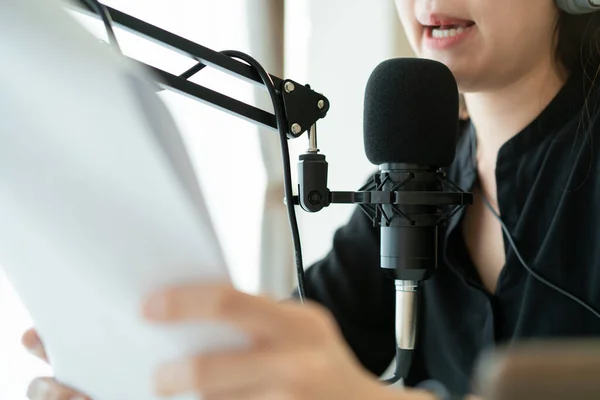 Güzel ve yakışıklı Asyalı kadın podcast kanalını düzenliyor. İş kadını internetteki yayını için bilgisayarından ve tabletinden canlı yayın yapıyor. Modern çalışma tarzı