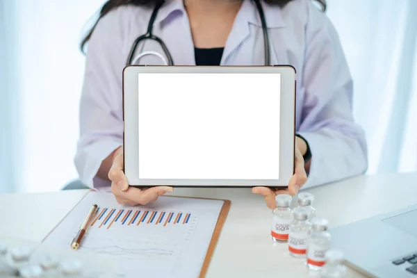 Unrecognizable specialist doctor holding an empty blank screen tablet isolated in white close up. Digital display in medication service advertisement. Mockup touchscreen tablet for ads.