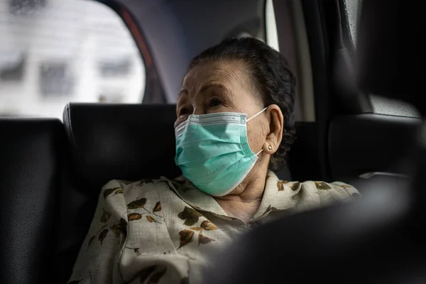 年龄在80 90岁之间的非常老的亚洲妇女乘坐私家车旅行 老年妇女在旅行时使用防护面罩 Coronavirus或Covid 19流行病概念 Covid19爆发 — 图库照片