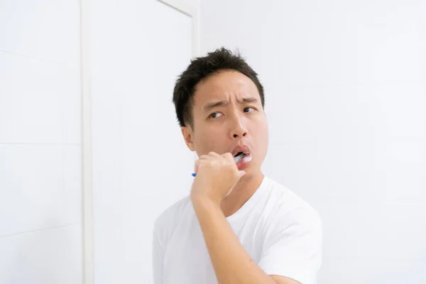 身穿白衬衫的亚洲年轻人起床后 在镜子前刷牙 享受口腔卫生和幸福 牙科护理概念 — 图库照片