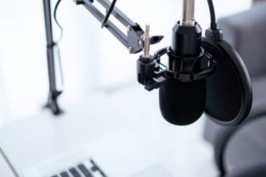 Bilgisayarda kopyalanmış kulaklıklı modern bir kulaklık var. Kulaklıklar kişisel defter bilgisayarında. Modern ses kayıt stüdyosu ve online radyo istasyonu. Canlı sesli buharlı ekipman.