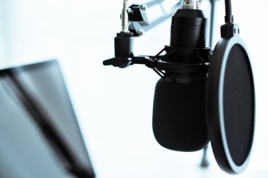 Ses kayıt stüdyosuna klipsleme yolu kurulmuş boş bir ekran ile Mockup laptop bilgisayar. Canlı buhar ve podcast internet radyo stüdyosu.