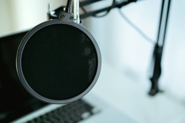 Bilgisayarda kopyalanmış kulaklıklı modern bir kulaklık var. Kulaklıklar kişisel defter bilgisayarında. Modern ses kayıt stüdyosu ve online radyo istasyonu. Canlı sesli buharlı ekipman.