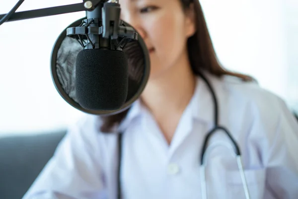 Asyalı doktor hastasıyla çevrimiçi video konferansı yapıyor. Tele-medikal servis konsepti. İnternet yayını üzerinden ilaç tavsiyesi veren kadın doktor.