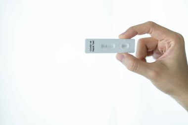 Hijyen koruyucu yüz maskesi takan Asyalı genç bir kadın SARS 2019-nCoV COVID-19 Coronavirus antijen hızlı test kiti kullanıyor. Evde tarımsal test kiti. COVID-19 antijen hızlı testi.