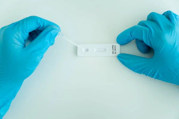 Hijyen koruyucu yüz maskesi takan Asyalı genç bir kadın SARS 2019-nCoV COVID-19 Coronavirus antijen hızlı test kiti kullanıyor. Evde tarımsal test kiti. COVID-19 antijen hızlı testi.