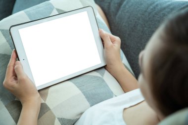 Maket tablet ekranındaki kırpma yolu ile izole edilmiş, oturma odasında kanepede otururken tablet kullanan ya da internette gezinen bir kadın - sosyal medya. Sosyal ağda sörf yapan kadın.