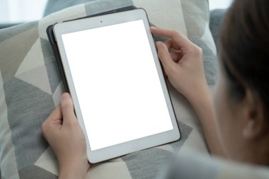 Maket tablet ekranındaki kırpma yolu ile izole edilmiş, oturma odasında kanepede otururken tablet kullanan ya da internette gezinen bir kadın - sosyal medya. Sosyal ağda sörf yapan kadın.