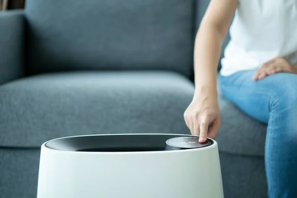 Aziatische Vrouw Het Inschakelen Van Moderne Luchtzuiveraar Tijdens Een Verblijf — Stockfoto