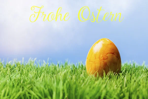 Deutscher Ostergruß Text; gelbes Osterei im Gras — Stockfoto