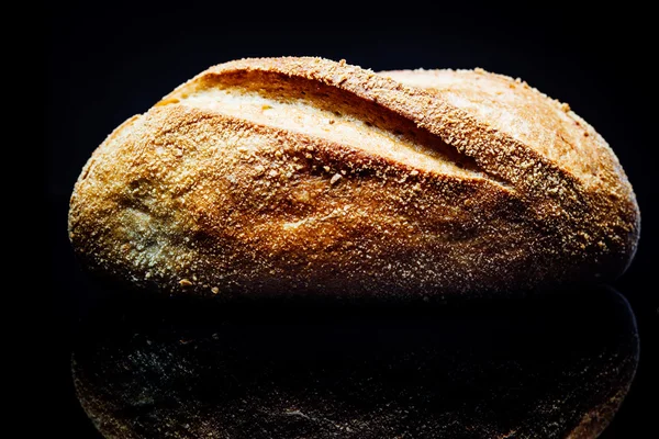 Rollo de pan de patata, sobre fondo negro, reflexión —  Fotos de Stock