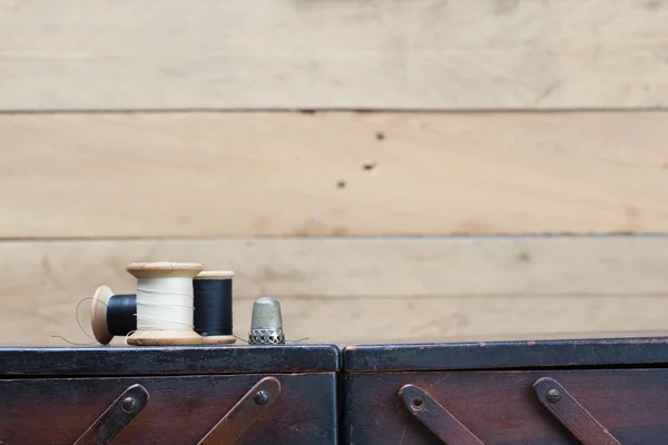 Roscas e ferramentas de bordado em cima do recipiente de madeira — Fotografia de Stock