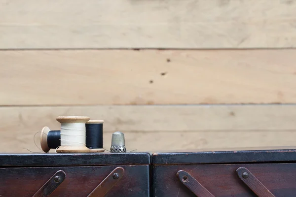 Threads and needlework tools on top of wooden container — Stock Photo, Image