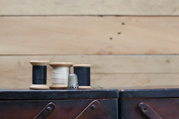 Hilos y herramientas de costura en la parte superior del contenedor de madera —  Fotos de Stock