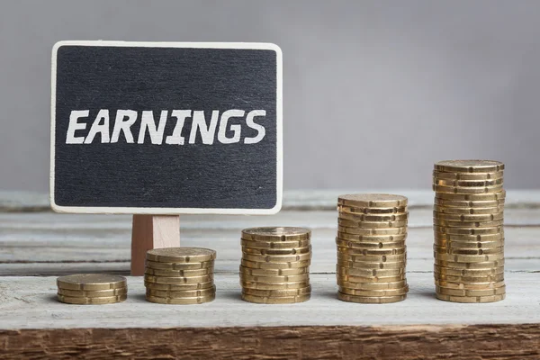 Word Earnings in white chalk type on black board — Stock Photo, Image