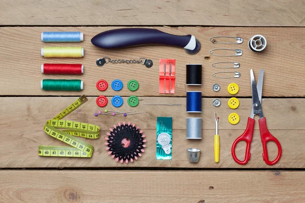 Set of tailoring tools on wooden background — Stock Photo, Image