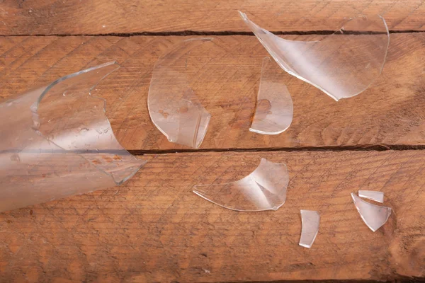 Gebroken glas stukken op houten achtergrond — Stockfoto