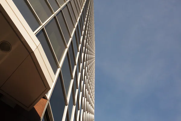 Vista de ángulo bajo del edificio de oficinas al lado del cielo — Foto de Stock