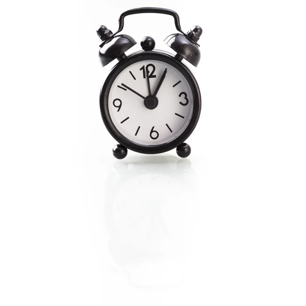 Black alarm clock showing one o clock — Stock Photo, Image