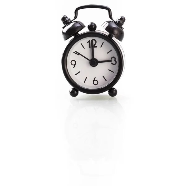 Black alarm clock showing three — Stock Photo, Image