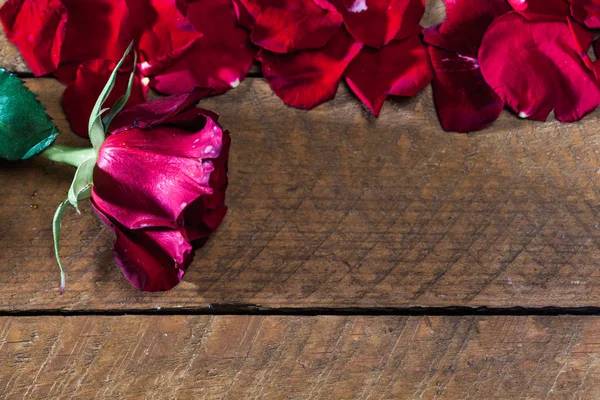 Kırmızı gül yaprakları, ahşap tahta üzerinde — Stok fotoğraf