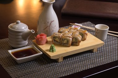 taze somon, füme yılan balığı, krem peynir ve salatalık içinde rulo yaptı. füme yılan balığı (unagi ile tepesinde)