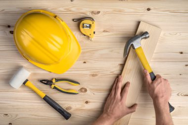Araçlar ve elleri çekiç ile ahşap arka plan üzerinde çalışma