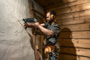 İnşaat işçisi matkap sorgulamaktı beton duvar