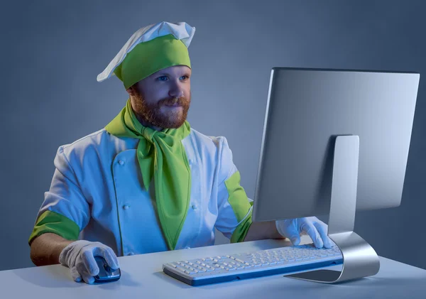 Cook chef working at a computer with keyboard and mouse — Stock Photo, Image