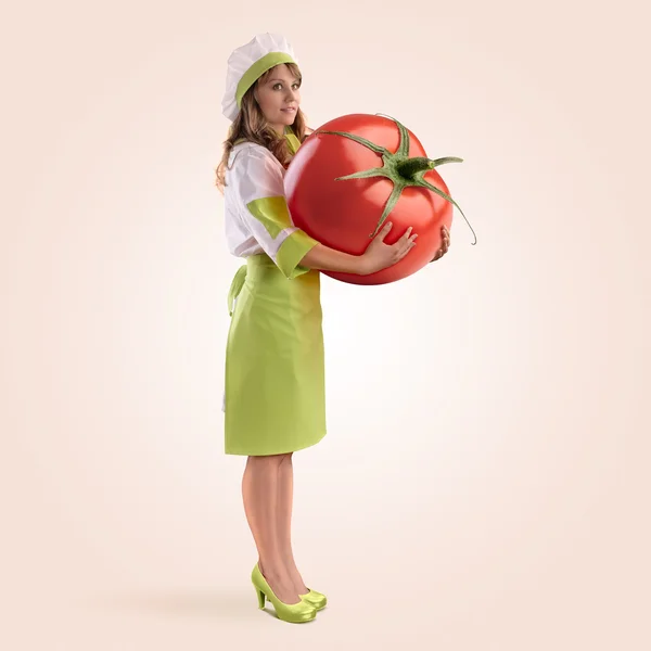 Μάγειρας κοπέλα που κρατά μια μεγάλη ντομάτα — Φωτογραφία Αρχείου