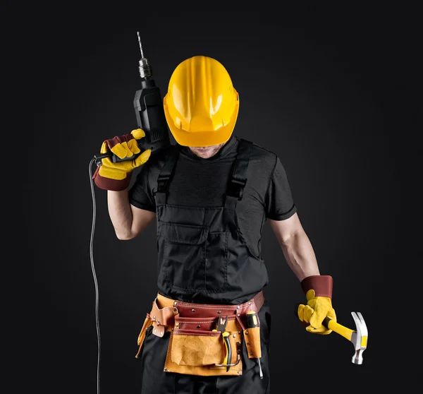 Byggnadsarbetare i hjälm med hammare och borr — Stockfoto