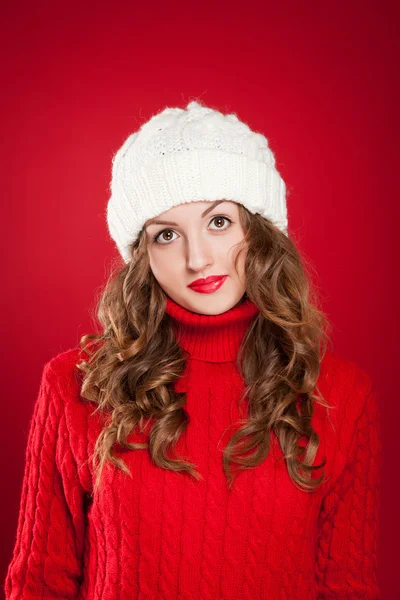 Sıcak şapka ve kırmızı kazak giyen kıvırcık saçlı güzel kız — Stok fotoğraf