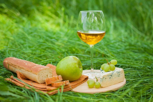 Stillleben mit Weißwein, Baguette, Käse, Trauben und Apfel — Stockfoto