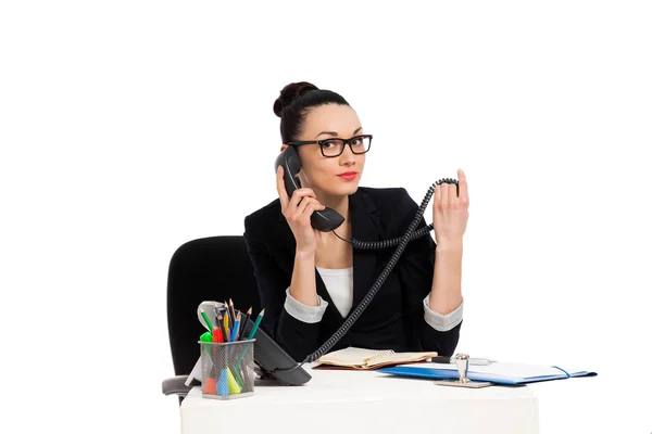 Brunette secretaris praten aan de telefoon zitten boven tafel — Stockfoto