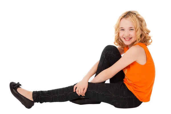 Little smiling girl in orange clothes and black shoes sitting — Stock Photo, Image