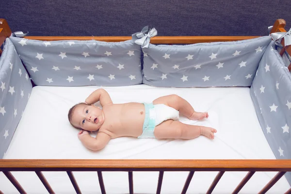 Infant baby laying in decorated cot — Stock Photo, Image
