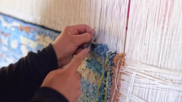 Woman weaving a carpet with traditional tools. Closeup of handmade craftmanship of carpet — Stock Video