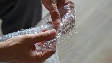 Ellerin plastik baloncuk ambalajında hava kabarcıkları açtığı videoyu kapat. Rahatlama, stres atma ve duyusal tatmin kavramı